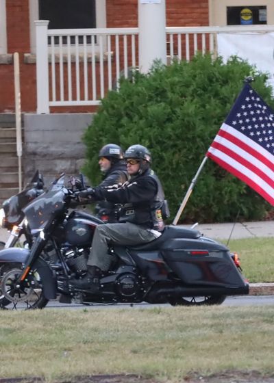 motorcycle escort carrying the American flag