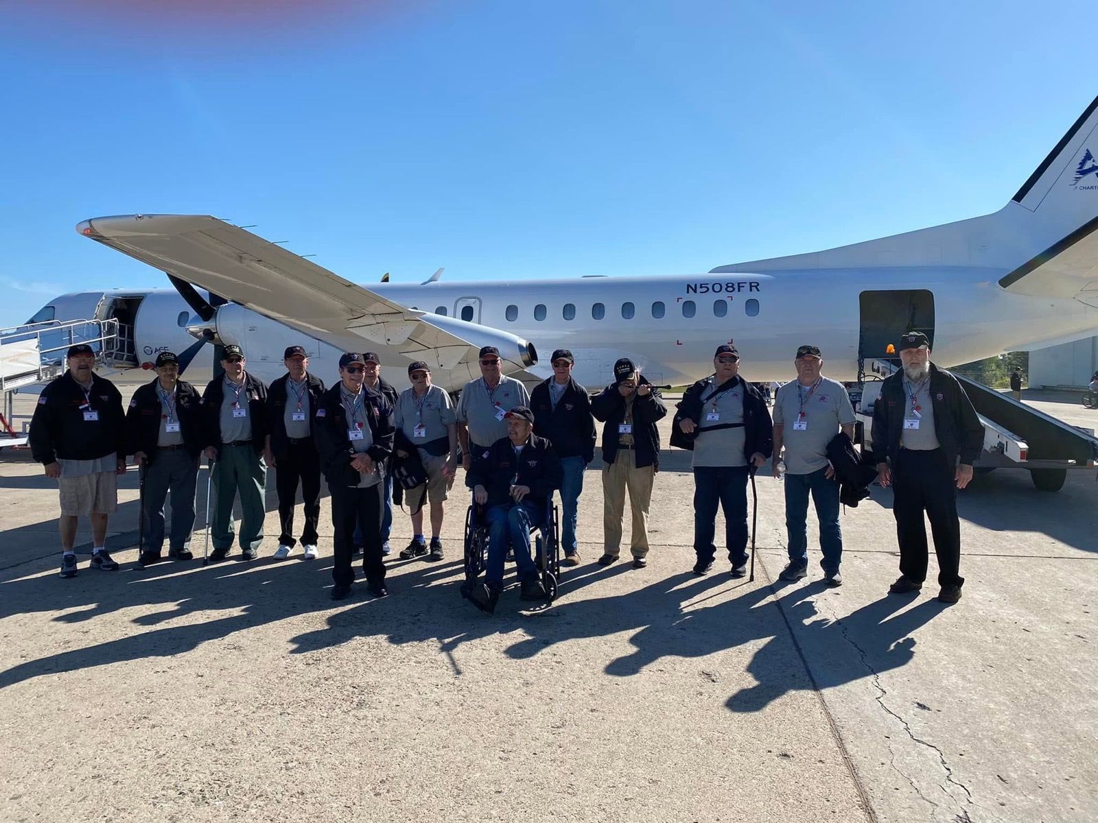 veterans gathered in front of their charter plane on an Honor Flight